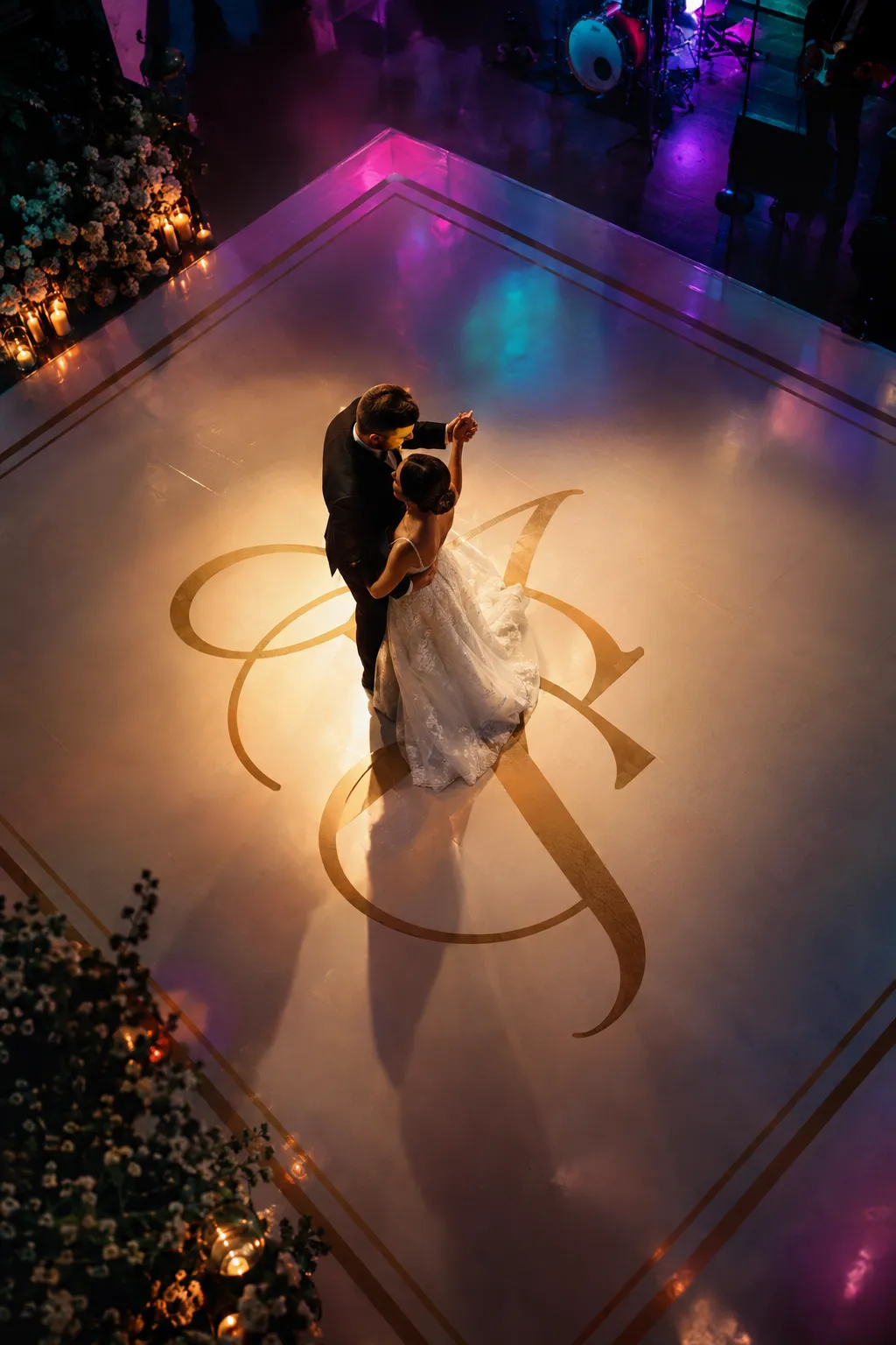 Pista de dança branca personalizada com monograma dourado e os noivos a dançar
